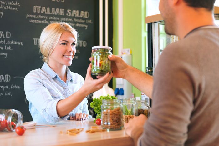 Customer ordering a grab n' go salad in a gourmet retail store
