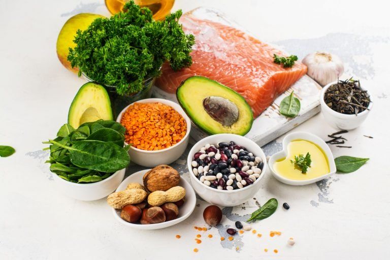 Superfoods representing a balanced diet including salmon, nuts, grians, fruits and vegetables.