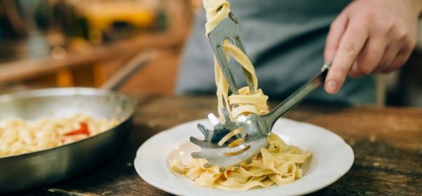male-chef-puts-fresh-pasta-in-a-plate-PTQ5JNM.jpg